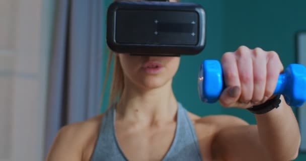 Close up portrait of girl in virtual reality glasses training at home using dumbbells and enjoying ar. Healthy lifestyle and vr simulation concept. Sport and fitness. — Stock Video