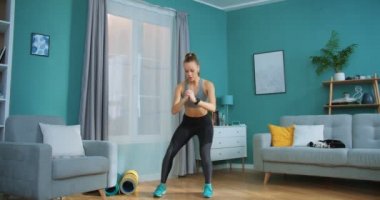 Genç bir kadın spor yapıyor, sağlıklı yaşam tarzı için egzersiz yapıyor ve evdeki oturma odasında güçlü karın kasları var. Spor ve spor. Eğitim, egzersiz ve sağlık konsepti.