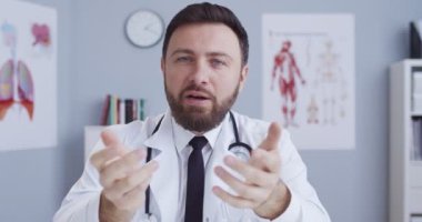 Klinikteki beyaz cübbeli yakışıklı beyaz erkek doktor blogcu internette sağlık hizmetleriyle ilgili danışmanlık yapıyor. Dostum, hastane çalışanı Qurantine sırasında internette tıbbi danışmanlık yapıyor..