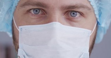 Doktor gözlerini kapat. Tıbbi maske takan doktor ya da cerrah hastane, klinik ya da ameliyathanede çalışmaya hazır olup salgın sırasında insanların sağlıklı kalmasına yardım ediyor.