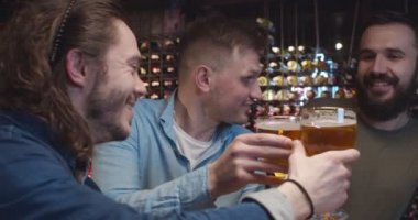 Beyaz erkek arkadaşlar spor maçı izlerken barda neşeleniyorlardı. Yakışıklı erkekler barda bir bardak birayla tezahürat yapıyor. Futbol taraftarları TV 'de maç izler ve içerler..