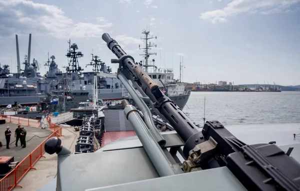 Machine gun on modern military battleship. Modern russian military battleships on background. Russia, Vladivostok.