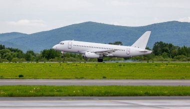 Havaalanı modern ticari yolcu uçağa iniş. Uçağın arkasında kasa altından duman.