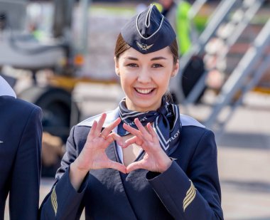 Rusya, Vladivostok, 10/13/2017. Güzel hostes Aeroflot Havayolları havaalanı üzerinde resmi koyu mavi üniforma giymiş. Arka plan üzerinde yolcu jet uçağı. Uçağının mürettebatı. Havacılık ve ulaşım.