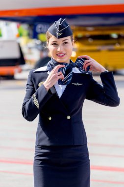 Rusya, Vladivostok, 10/13/2017. Güzel hostes Aeroflot Havayolları havaalanı üzerinde resmi koyu mavi üniforma giymiş. Arka plan üzerinde yolcu jet uçağı. Uçağının mürettebatı. Havacılık ve ulaşım.