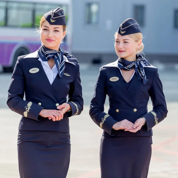 Rusya, Vladivostok, 10/13/2017. Güzel hostes Aeroflot Havayolları havaalanı üzerinde resmi koyu mavi üniforma giymiş. Arka plan üzerinde yolcu jet uçağı. Uçağının mürettebatı. Havacılık ve ulaşım.
