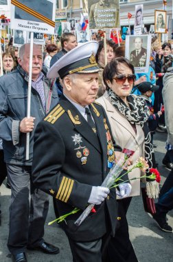 Rusya, Vladivostok, 05/09/2015. İnsanlar onların yakınları, SSCB ve Nazi Almanya'sı arasında büyük Vatanseverlik Savaşı katılımcıların portreleri tutun. Ölümsüz alayın olay yıllık zafer günü ' 9 Mayıs.