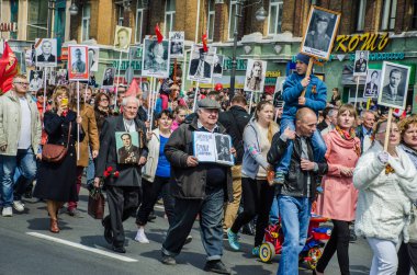 Rusya, Vladivostok, 05/09/2015. İnsanlar onların yakınları, SSCB ve Nazi Almanya'sı arasında büyük Vatanseverlik Savaşı katılımcıların portreleri tutun. Ölümsüz alayın olay yıllık zafer günü ' 9 Mayıs.