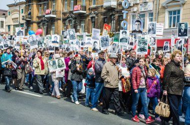 Rusya, Vladivostok, 05/09/2015. İnsanlar onların yakınları, SSCB ve Nazi Almanya'sı arasında büyük Vatanseverlik Savaşı katılımcıların portreleri tutun. Ölümsüz alayın olay yıllık zafer günü ' 9 Mayıs.