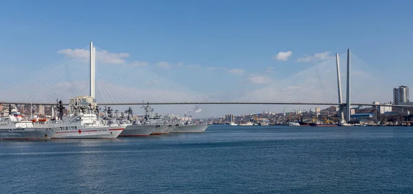 View on Golden Horn Bay (or Zolotoy Rog) with Golden Bridge (or Zolotoy bridge) and parking of military battleships of Russian Pacific Navy with few battle ships (cruisers). Russia, Vladivostok.