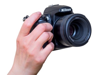 Russia, Vladivostok, 02/22/2018. Female hand with modern DSLR camera Nikon D7000 with lens Nikon AF-S 50 mm f/1.8G mounted. Nikon photography equipment. Isolated on white. clipart
