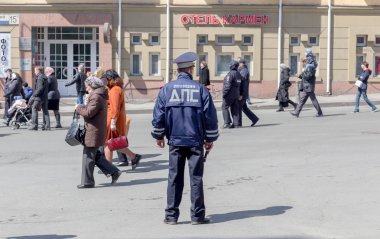 Rusya, Vladivostok, 04/08/2018. Bir polis şehir merkezindeki yürüyen insanlar izliyor. 