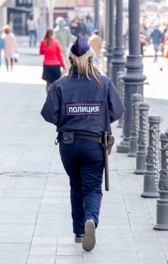 Bir kadın polis şehir şehir merkezinde sokakta yürüyor. 