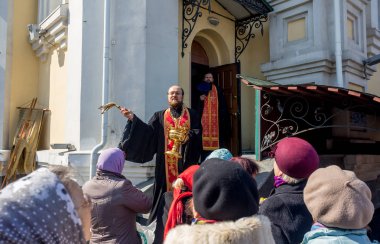 Rusya, Vladivostok, 04/08/2018. Paskalya töreni kilise bahçesinde, Paskalya kek, yumurta ve diğer yemekler kutsama. Yağmurlama kutsal su. Paskalya Ortodoks Hıristiyanlığın ana tatilidir.