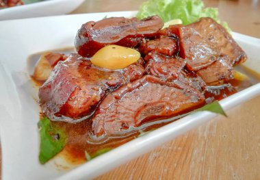 Tay gıda Komposto domuz eti (Moo Hong) kahverengi ahşap masa ile beyaz tabak, Phuket, Tayland için popüler yerel gıda