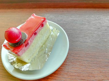 çilek ve yoğurt beyaz pasta tabağı ile sabah aydınlatma ile kahverengi ahşap masa.