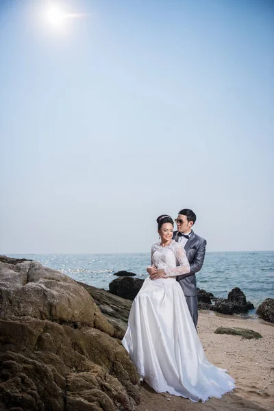Asian couple wearing wedding dress and suit for beach wedding ce