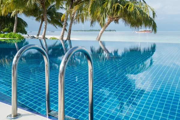 Pool stair with infinity pool and seascape as blurry background