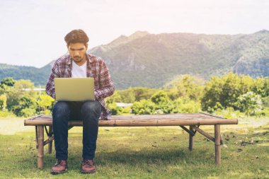 Dizüstü bilgisayarda çalışan adam. Doğa arka plan.