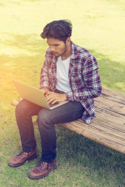 Dizüstü bilgisayarda çalışan adam. Doğa arka plan.