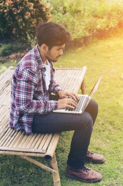 Dizüstü bilgisayarda çalışan adam. Doğa arka plan.
