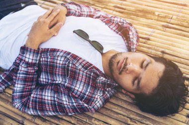 Genç adam almak nap bambu yatak veya koltuk