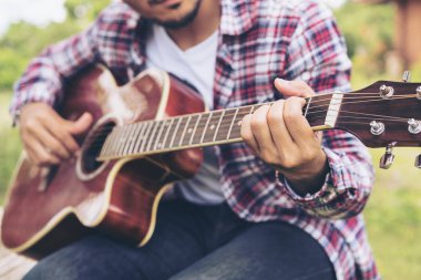 Adamın elini yeşil çimlere oturup gitar çalmak