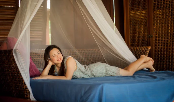 Woman relaxing on a boutique bed — Stock Photo, Image