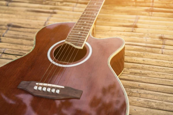 Acoustic guitar placed on a wooden table — Stock Photo, Image