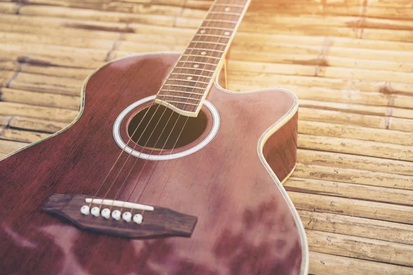 Acoustic guitar placed on a wooden table — Stock Photo, Image