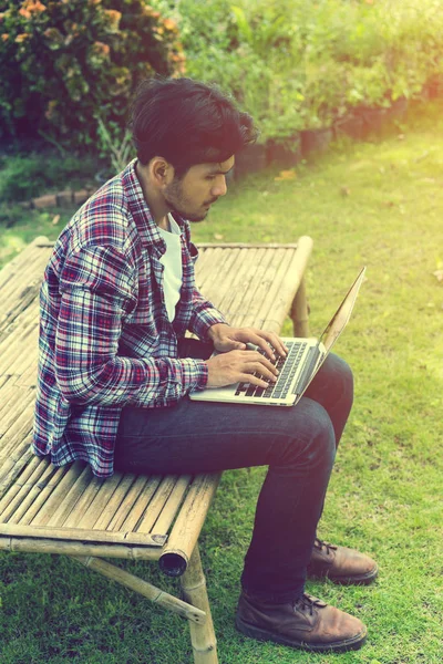 Man working on laptop. Nature background.