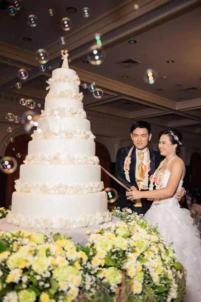 Sposa e sposo stanno tagliando la torta per festeggiare il loro matrimonioin — Foto Stock
