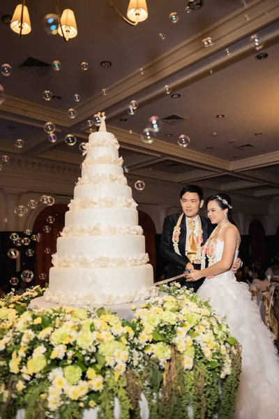 Nevěsta a ženich jsou řezání dort na oslavu na jejich svatební — Stock fotografie