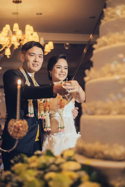 Nevěsta a ženich jsou řezání dort na oslavu na jejich svatební — Stock fotografie