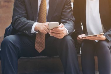 İki iş adamları iş ilişkisi cep telefonu üzerinde tartışmak.