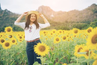 Ayçiçeği alan mutlulukla gülümseyerek mutlu bir kadın