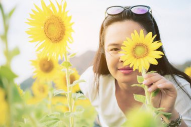 Ayçiçeği ve arkasında saklanıyor bir kadın