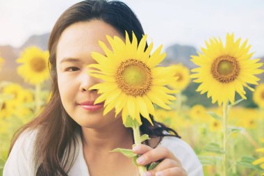 Ayçiçeği ve arkasında saklanıyor bir kadın