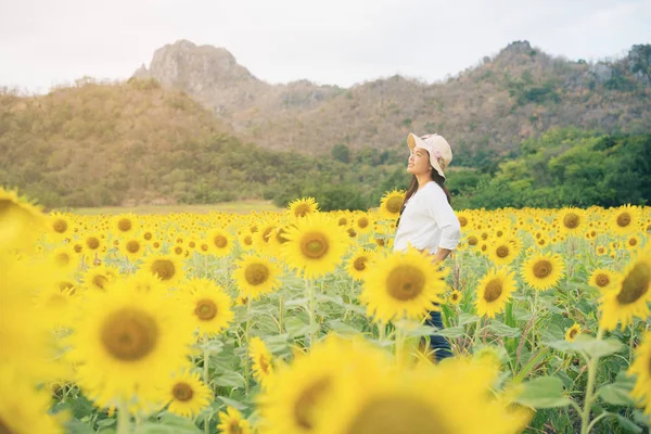 Gelukkige vrouw in zonnebloem veld glimlachend met geluk — Stockfoto