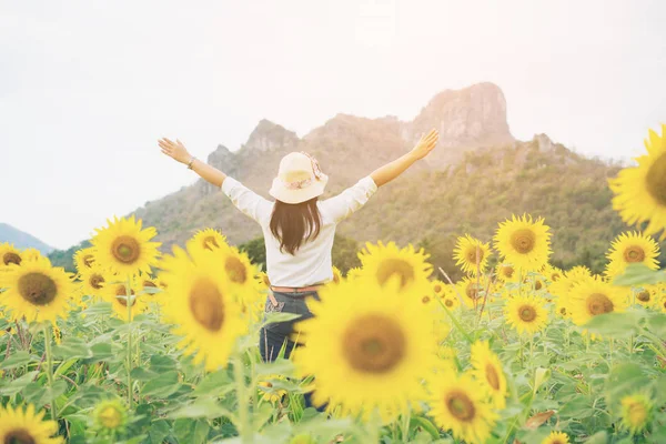 Gelukkige vrouw in zonnebloem veld glimlachend met geluk — Stockfoto