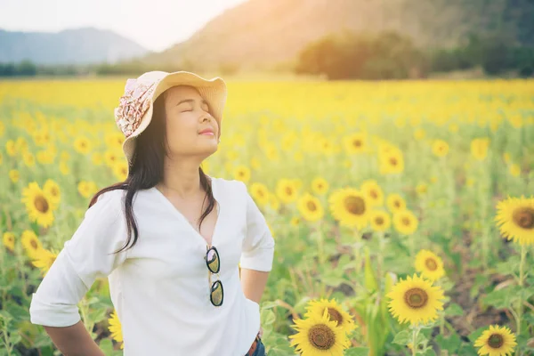 Gelukkige vrouw in zonnebloem veld glimlachend met geluk — Stockfoto