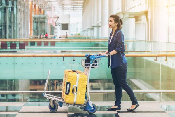 Туристическая женщина в терминале аэропорта с багажом — стоковое фото