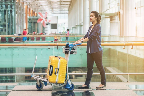 Туристическая женщина в терминале аэропорта с багажом — стоковое фото