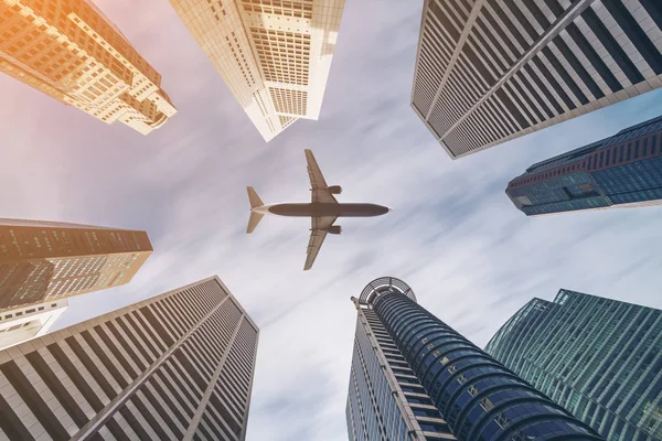 Repülőgép repül át a város üzleti épületek, sokemeletes skyscrap — Stock Fotó