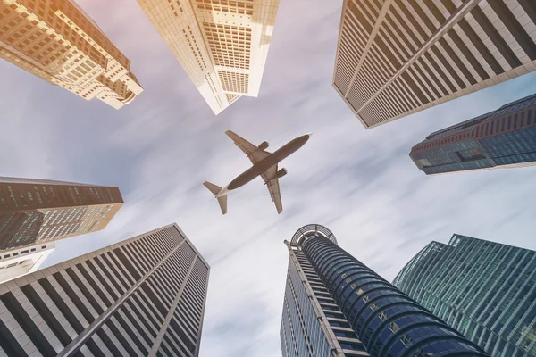 Repülőgép repül át a város üzleti épületek, sokemeletes skyscrap — Stock Fotó