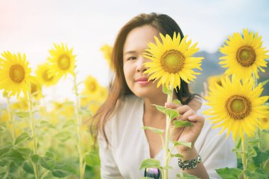 Ayçiçeği ve arkasında saklanıyor bir kadın