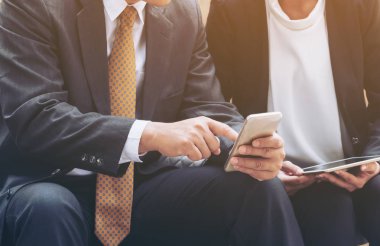 İki iş adamları iş ilişkisi cep telefonu üzerinde tartışmak.