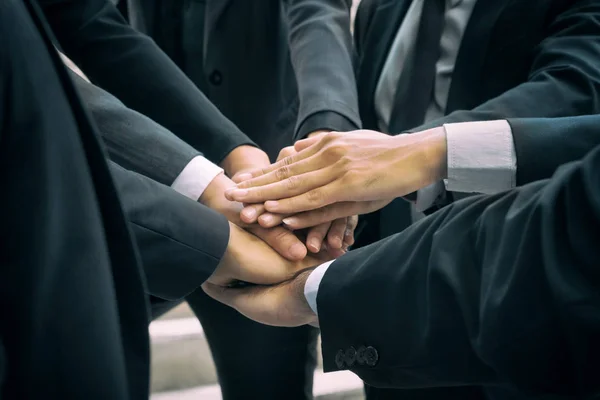 Gli uomini d'affari che uniscono le mani mostrando lavoro di squadra — Foto Stock