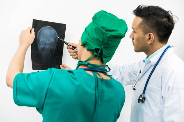 Lékaři při pohledu na rentgenový film z hlavy pacienta — Stock fotografie