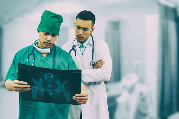 Cirujano y médico mirando la película de rayos X . — Foto de Stock